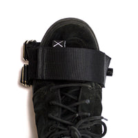 A black Restrap horizontal pedal strap fitted onto a cycling pedal, with visible nylon webbing and metal buckle.