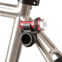 A black Restrap Light Mount attached to a bicycle frame, with a light on top.