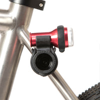 A black Restrap Light Mount attached to a bicycle frame, with a light on top.