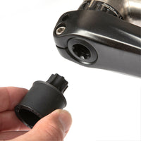 A black Restrap Light Mount being used as a crank extraction tool