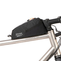 A black Race Top Tube Bag bolted to the top tube of a bicycle, featuring a YKK aquaguard zip and reflective detailing.