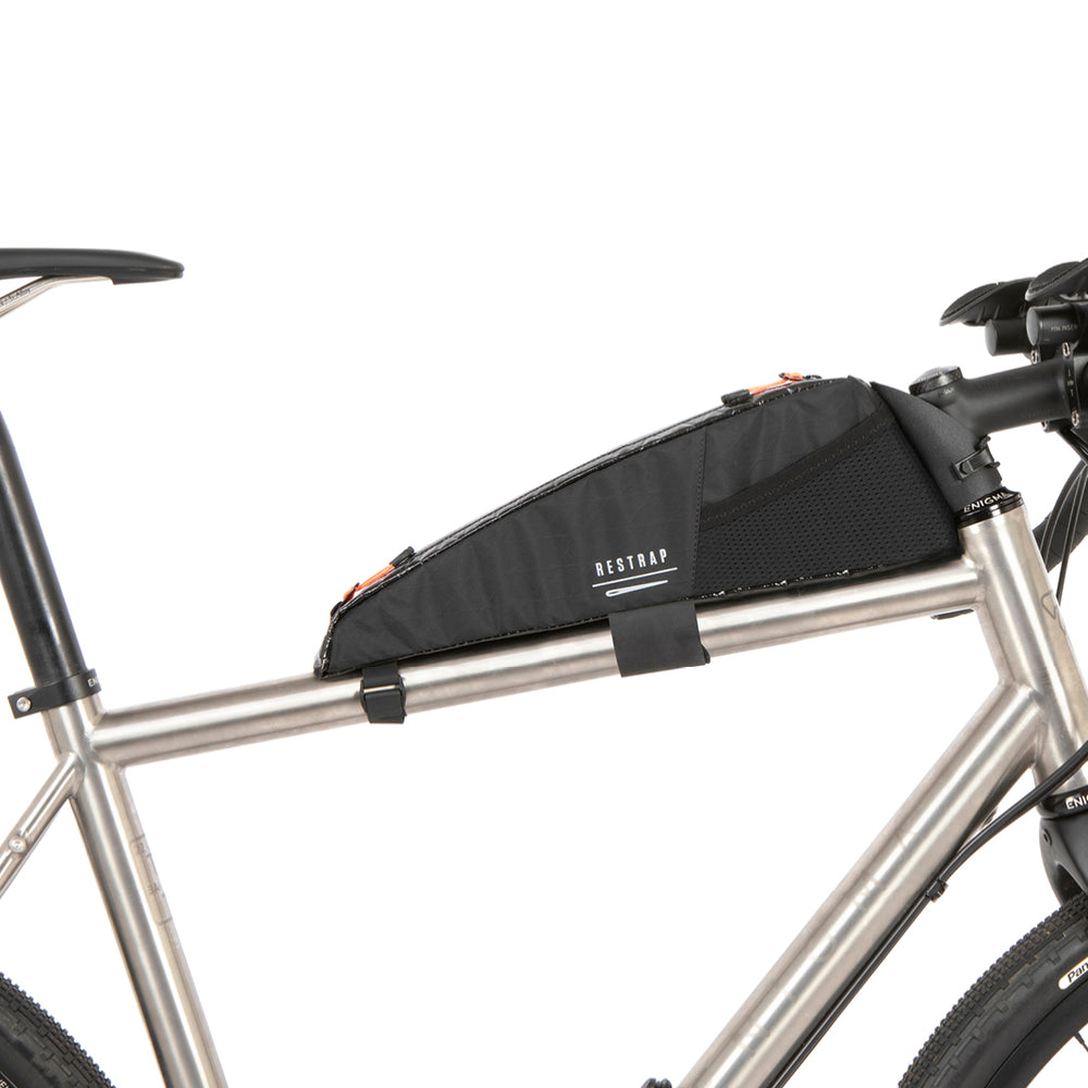 A black Race Top Tube Bag attached to the frame of a bicycle, designed to hold items while cycling.