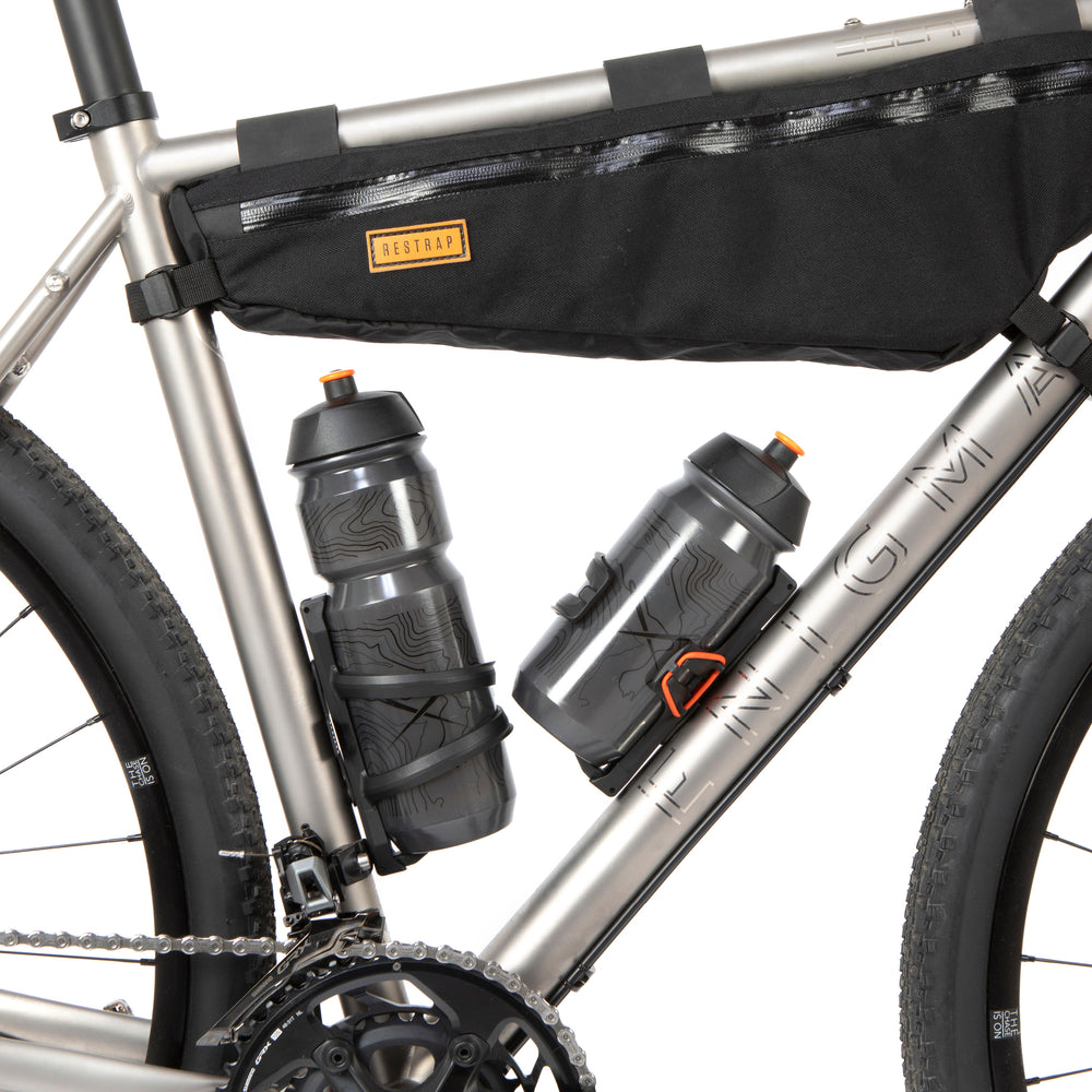 A black side release bottle cage mounted on a bicycle frame, with a side entry opening.
