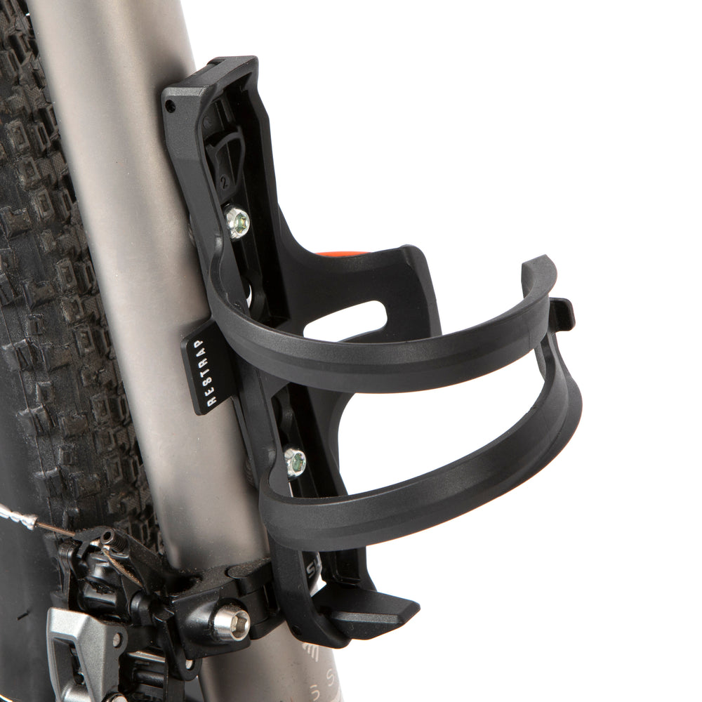 A black side release bottle cage mounted on a bicycle frame, with a side entry opening.