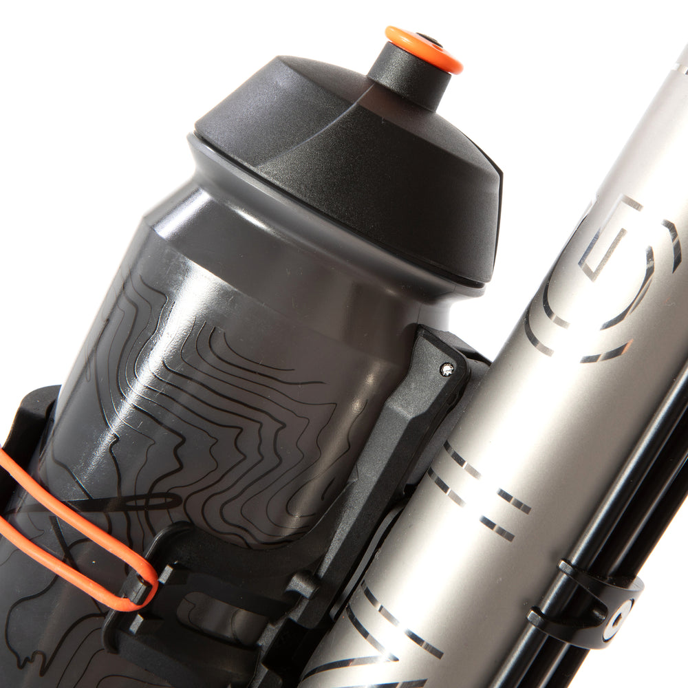 close up of A black side release bottle cage mounted on a bicycle frame, with a side entry opening.