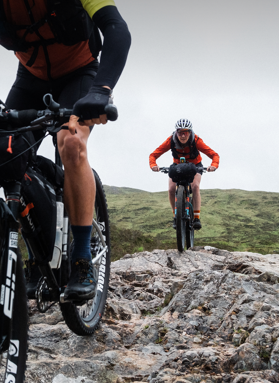 female rider chasing male rider on offroad trail