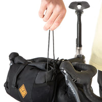A black Restrap Holster Bar Bag Plus showing shoulder strap being removed