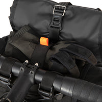 Close up of black Restrap Holster Bar Bag Plus mounted on a bicycle handlebar, showing the strap fixing