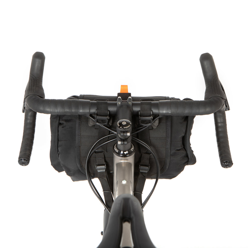 A shot of the rear of a restrap holster bar bag attached to the handlebars of a bicycle, designed for bikepacking.