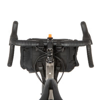 A shot of the rear of a restrap holster bar bag attached to the handlebars of a bicycle, designed for bikepacking.