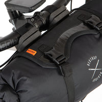 Black bikepacking bag with straps attached to a bicycle handlebar, featuring the Restrap logo.