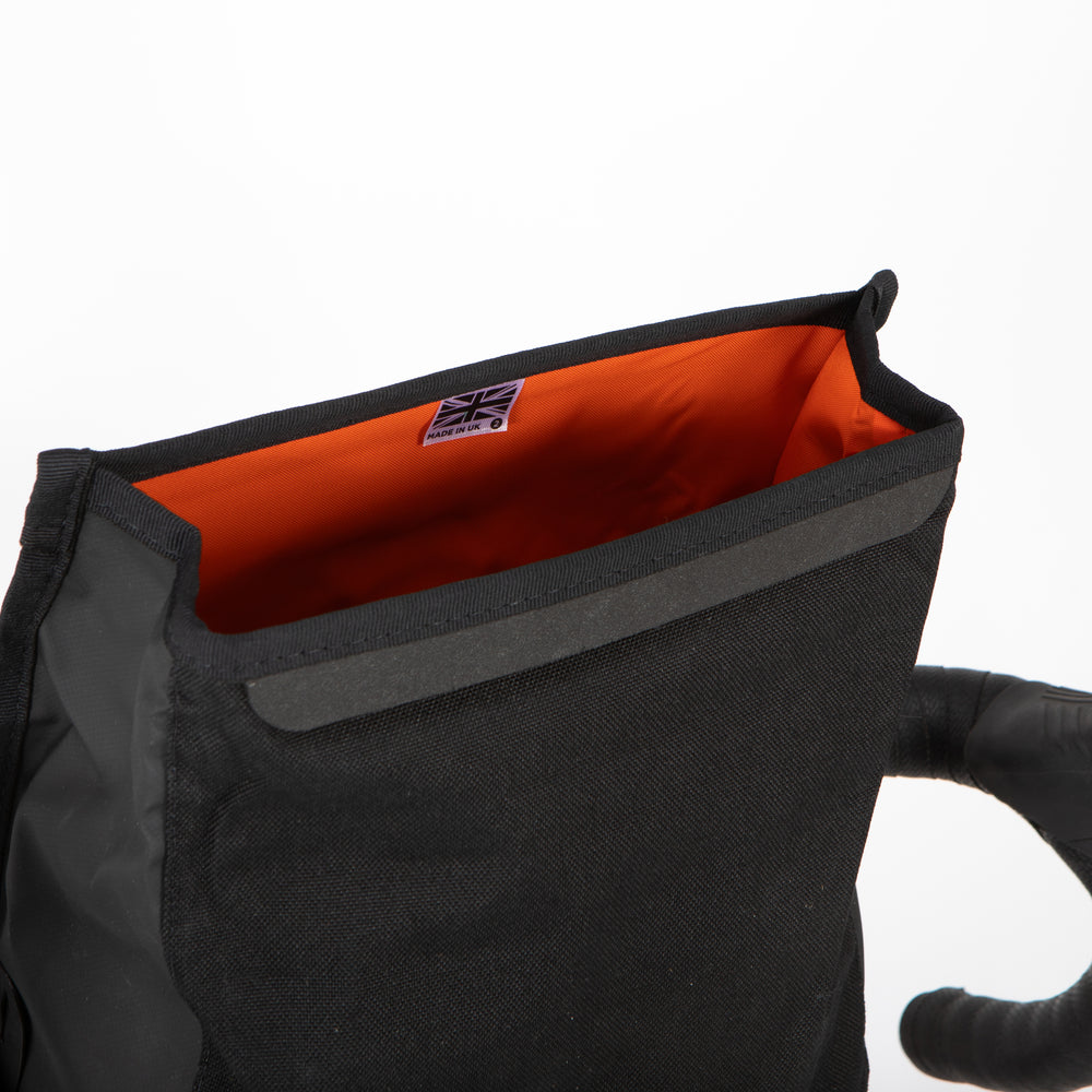 the opening of a rolltop canister bag shown on a white background