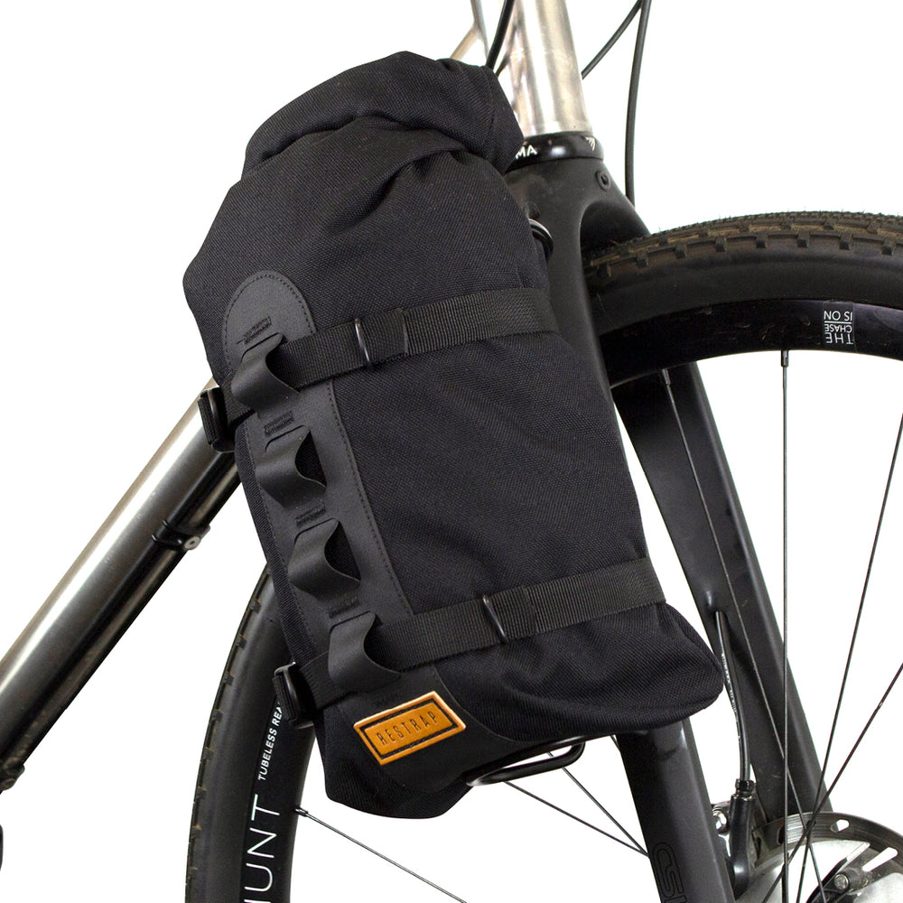 A black Restrap Fork Bag attached to a bicycle fork cage, designed to be waterproof and carry 5 liters.