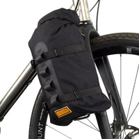 A black Restrap Fork Bag attached to a bicycle fork cage, designed to be waterproof and carry 5 liters.