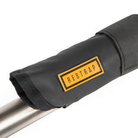 A black hike a bike harness attached to the frame of a bicycle, designed for carrying the bike on one's back.