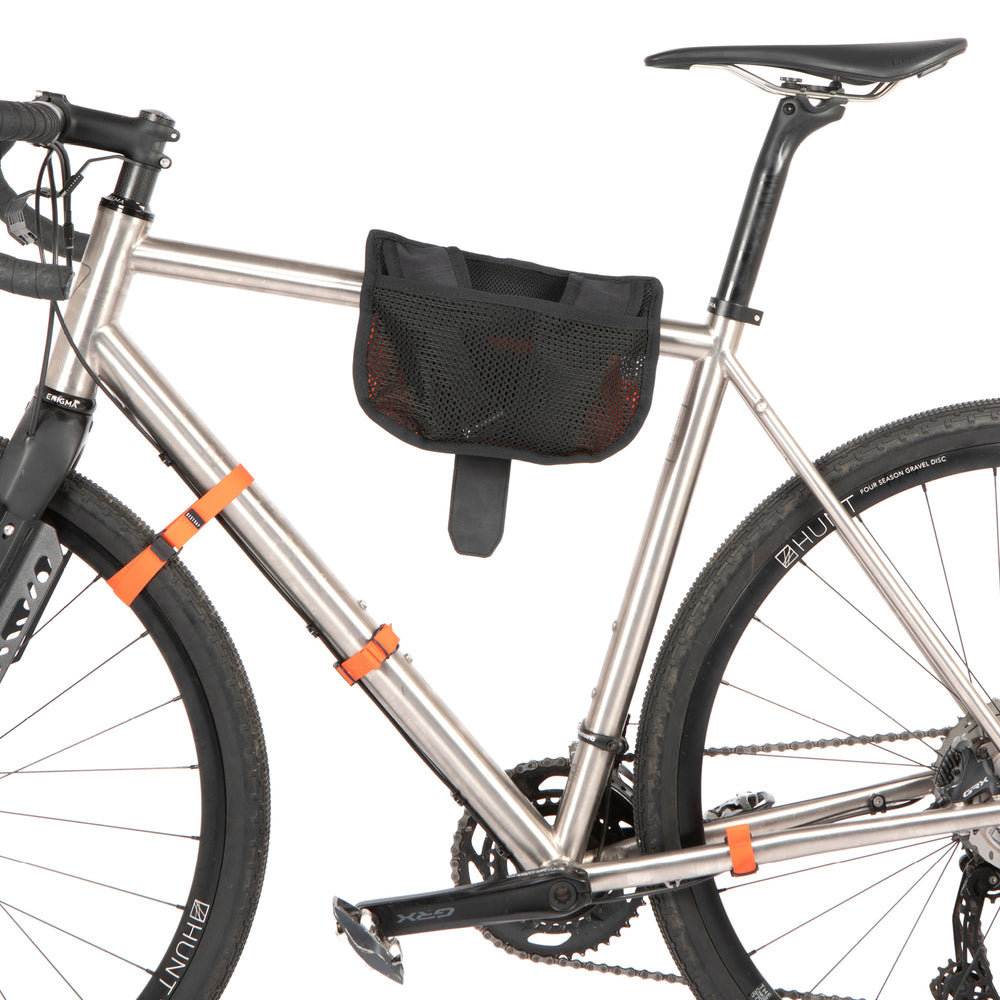A black hike a bike harness attached to the frame of a bicycle, designed for carrying the bike on one's back.