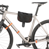 A black hike a bike harness attached to the frame of a bicycle, designed for carrying the bike on one's back.