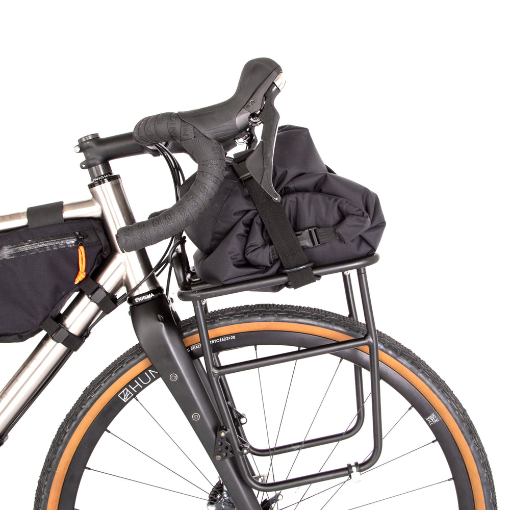 Restrap luggage straps with rubber o-rings and magnetic buckles on a white background holding bags onto a front rack on a bicycle