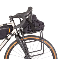 Restrap luggage straps with rubber o-rings and magnetic buckles on a white background holding bags onto a front rack on a bicycle