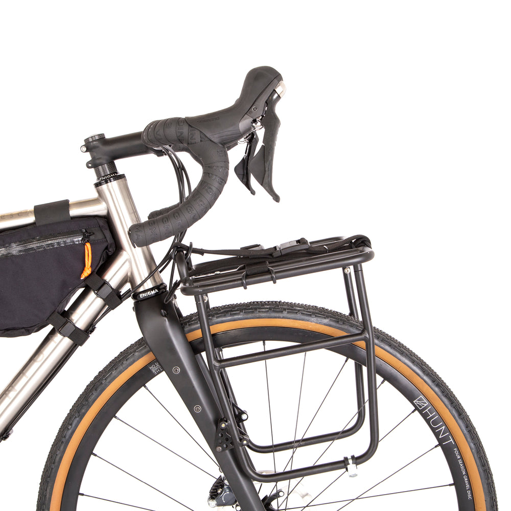 Restrap luggage straps with rubber o-rings and magnetic buckles on a white background mounted onto a front rack on a bicycle