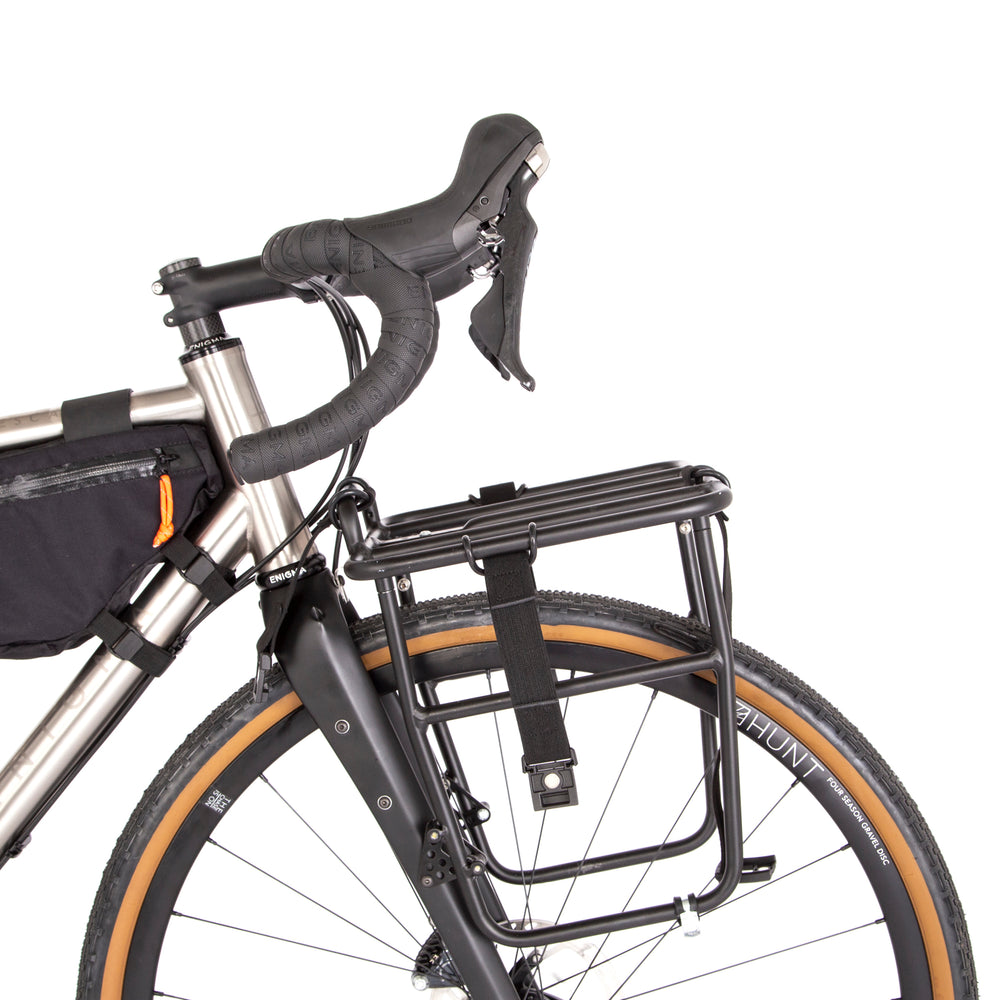 Restrap luggage straps with rubber o-rings and magnetic buckles on a white background mounted onto a front rack on a bicycle