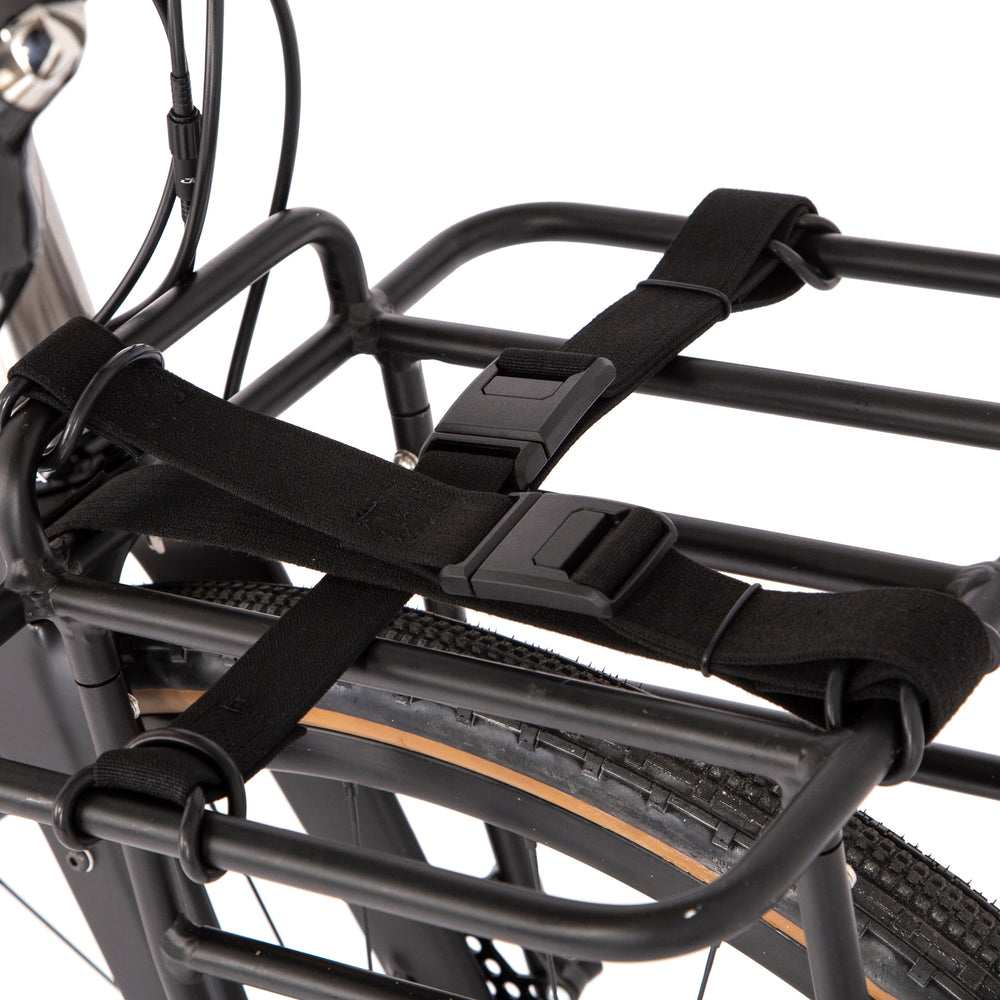 Restrap luggage straps with rubber o-rings and magnetic buckles on a white background mounted onto a front rack on a bicycle