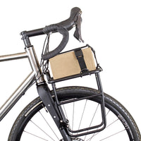 Restrap luggage straps with rubber o-rings and magnetic buckles on a white background holding a box onto a front rack on a bicycle