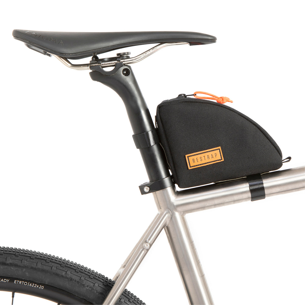 A black Rear Top Tube Bag attached to the top tube of a bicycle just below the seat, featuring a simple zip closure and a small label with the brand name.