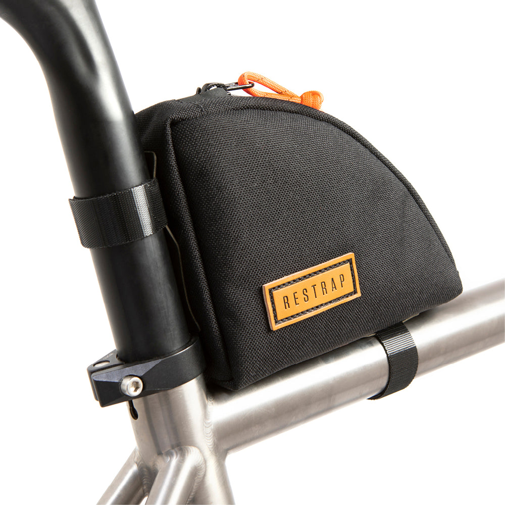 A black Rear Top Tube Bag attached to the top tube of a bicycle just below the seat, featuring a simple zip closure and a small label with the brand name.