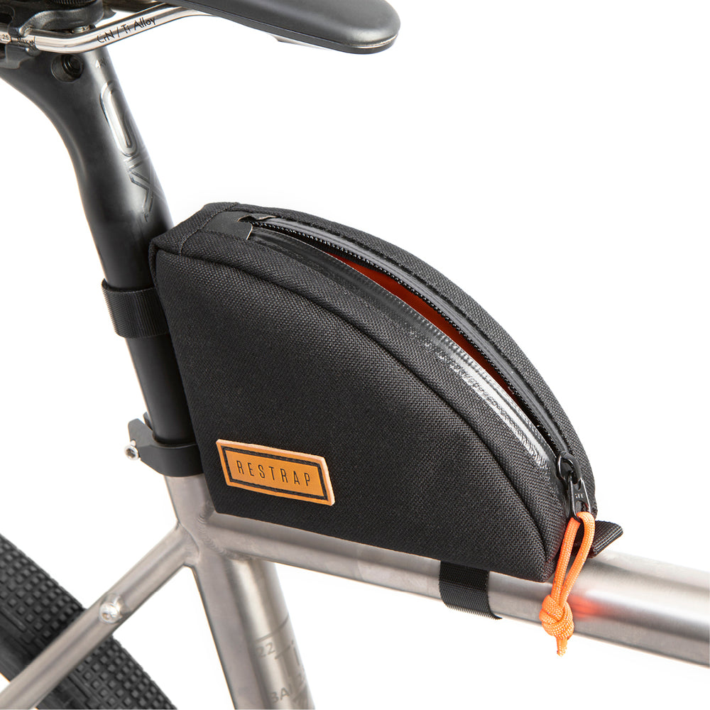A black Rear Top Tube Bag attached to the top tube of a bicycle just below the seat, featuring a simple zip closure and a small label with the brand name.