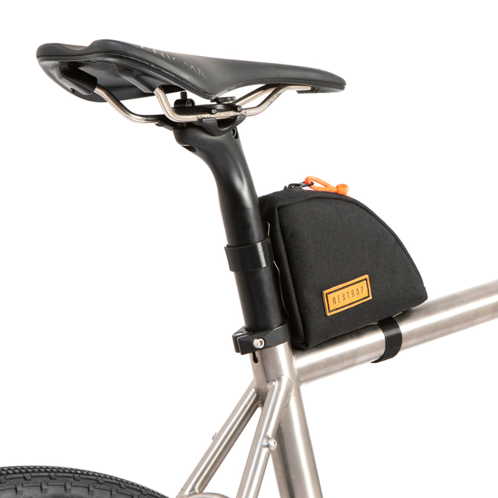 A black Rear Top Tube Bag attached to the top tube of a bicycle just below the seat, featuring a simple zip closure and a small label with the brand name.