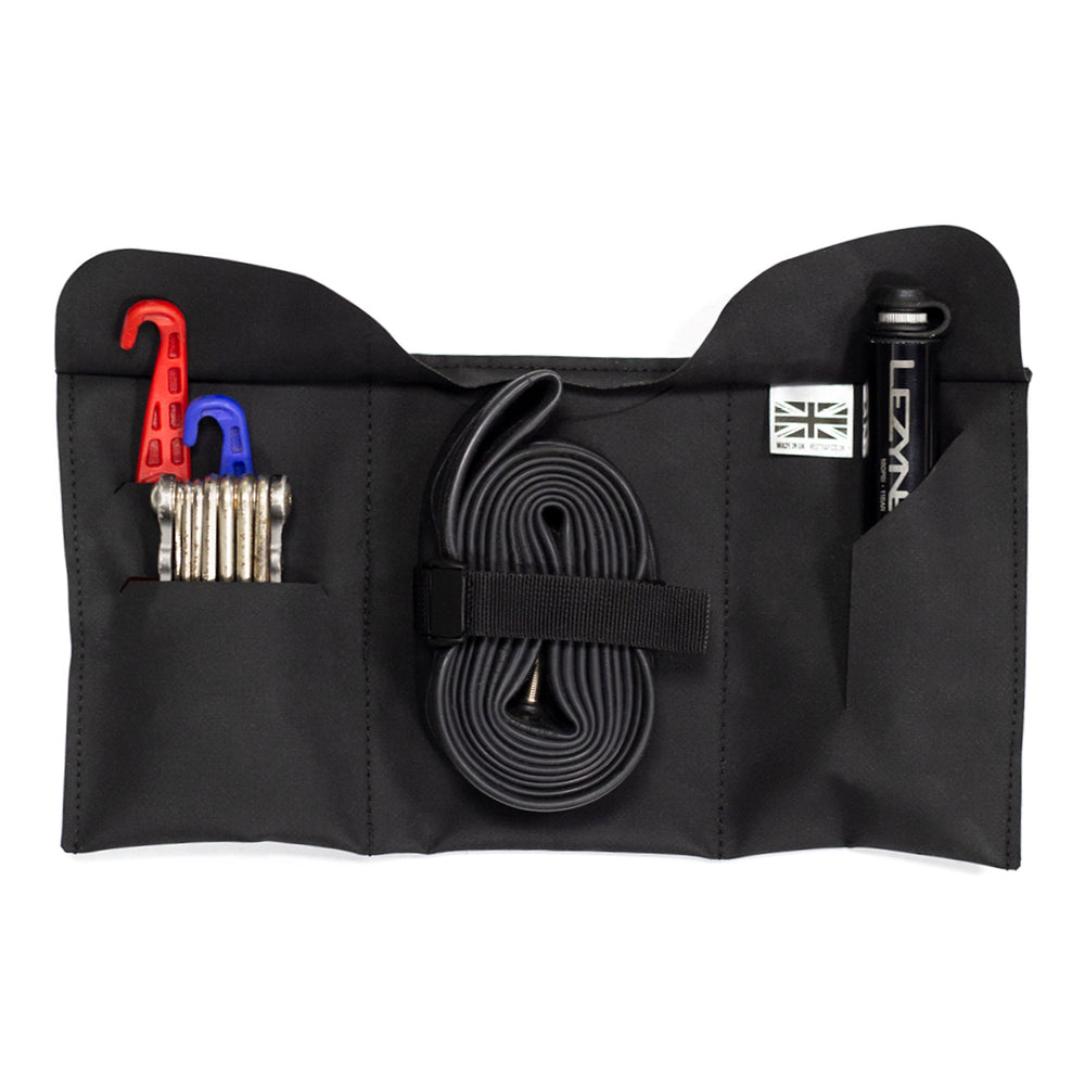 A black Restrap tool roll with a visible brand label, designed to be attached to a bicycle saddle or kept in a jersey pocket.