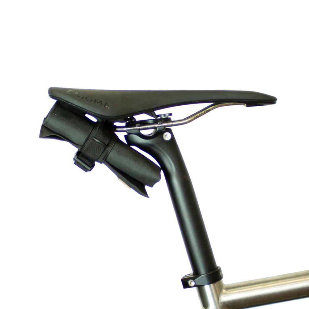 A black Restrap tool roll with a visible brand label, designed to be attached to a bicycle saddle or kept in a jersey pocket.
