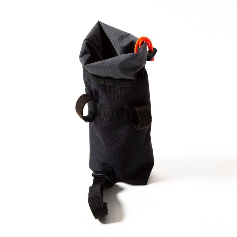 A black Restrap stem bag, designed for carrying a water bottle or other items, with an orange drawstring and the Restrap logo in yellow, showing the fitting straps