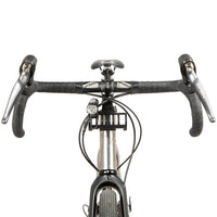 A black metal bumper bar mounted on a bicycle handlebarwith a light attached