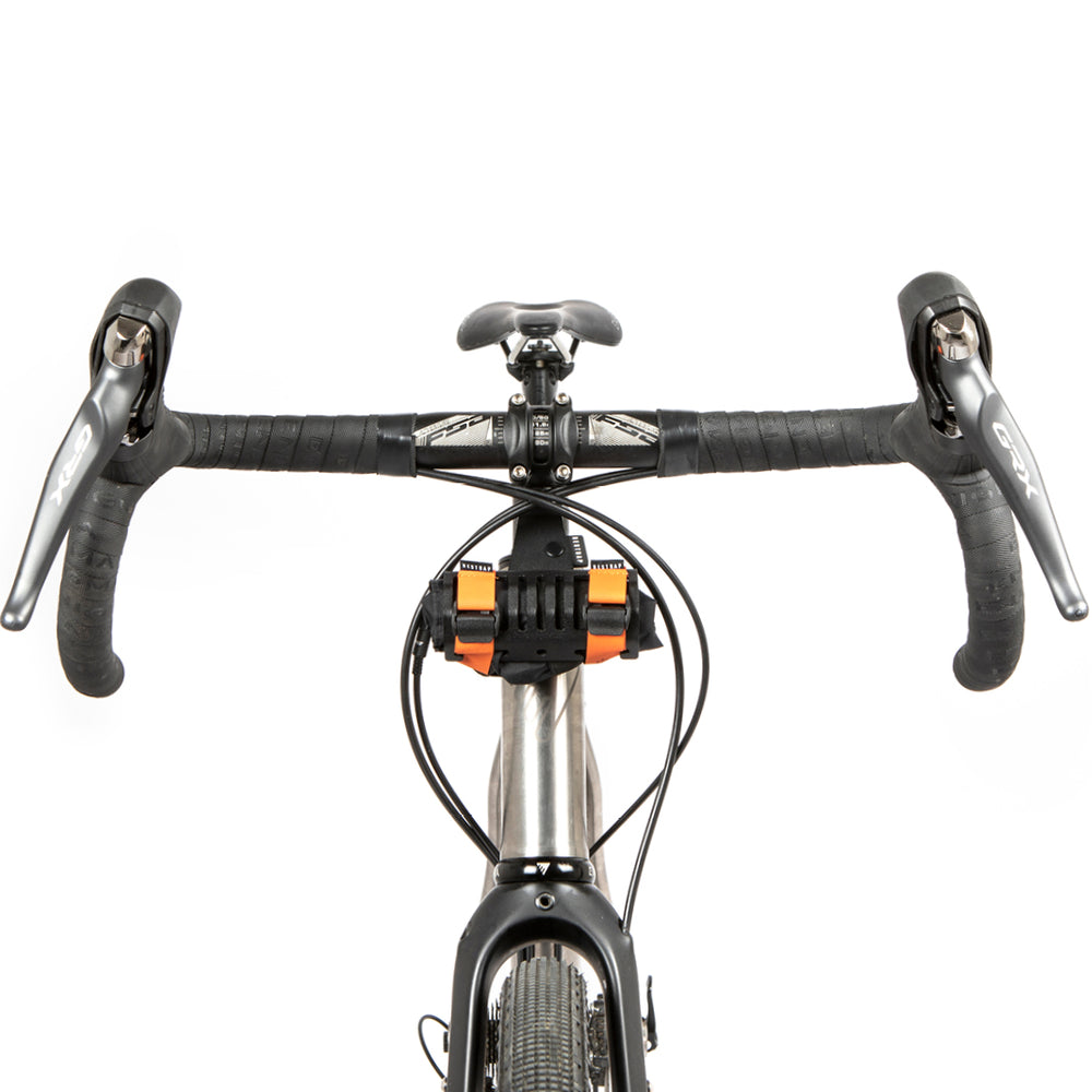 A black metal bumper bar mounted on a bicycle handlebar with a small wrap attached