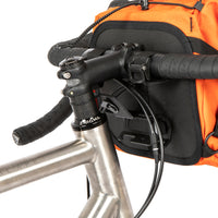 A black metal bumper bar mounted on a bicycle handlebar designed for spacing a handlebar bag further outwards and upwards