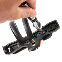 Close-up of a hand using a tool on a bottle cage and switch multi mount with orange accents.